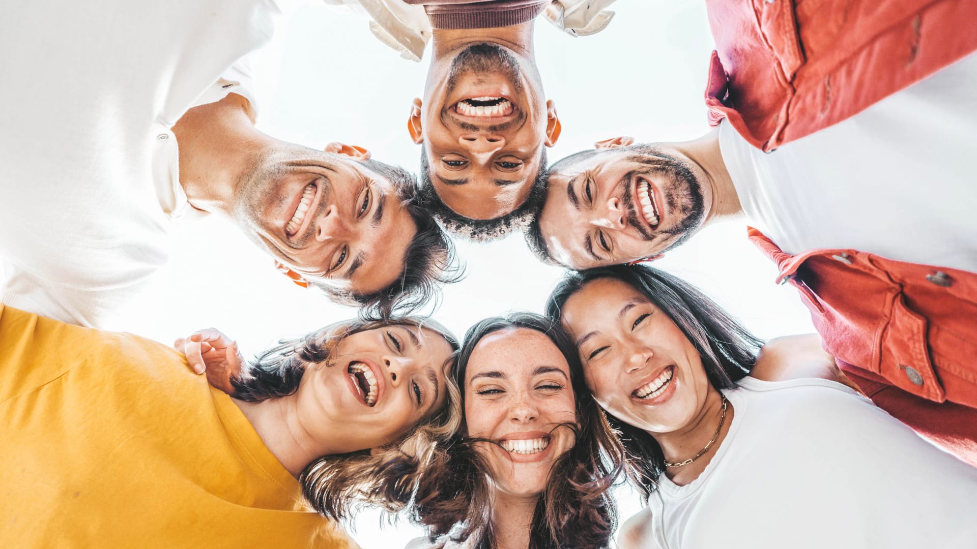 Im Kreis stehende Solopreneure blicken von oben auf die Kamera herunter.