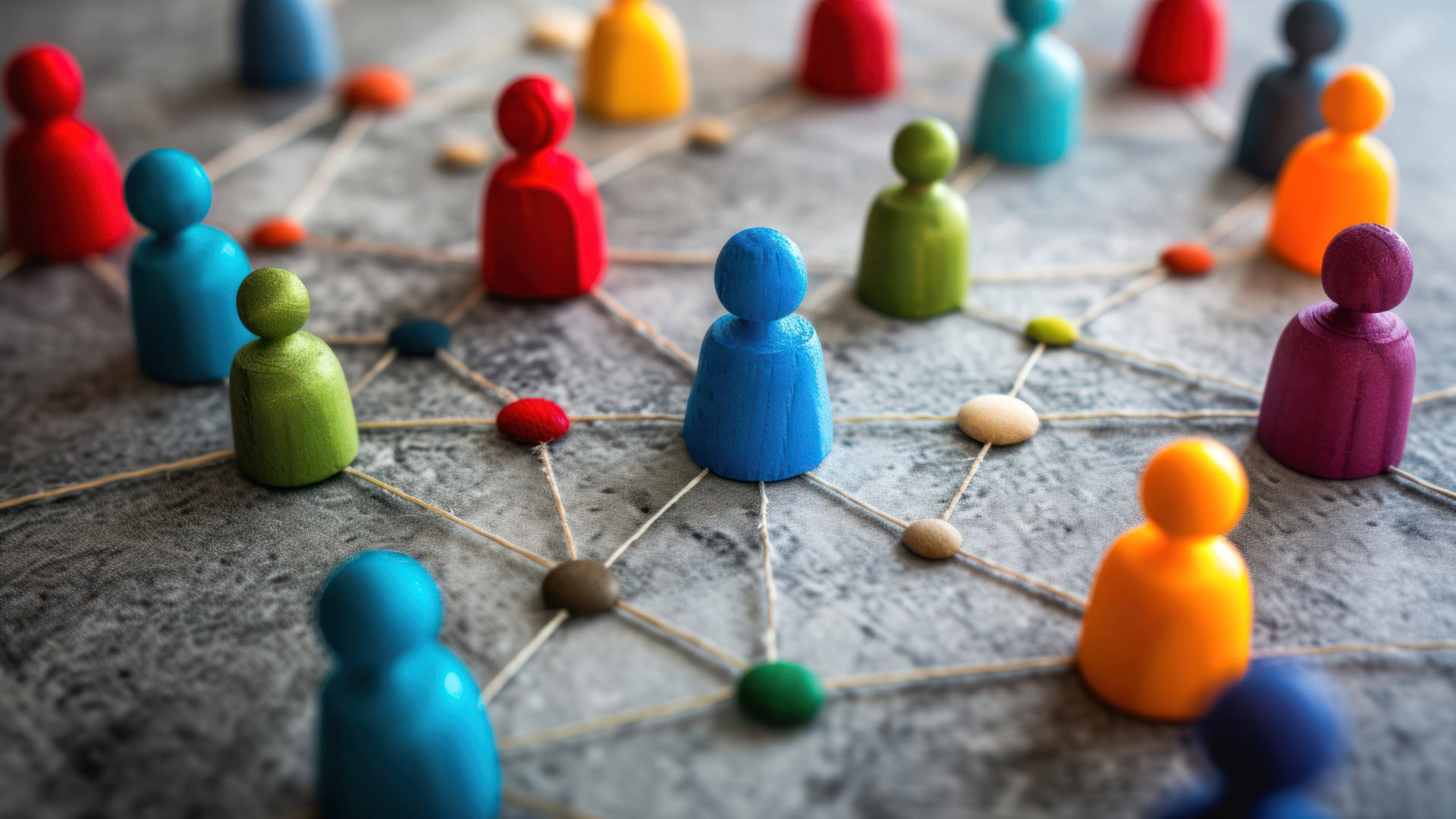 Bunte Spielfiguren, die untereinander mit Fäden vernetzt sind und stellvertretend für Kundensegmente stehen.