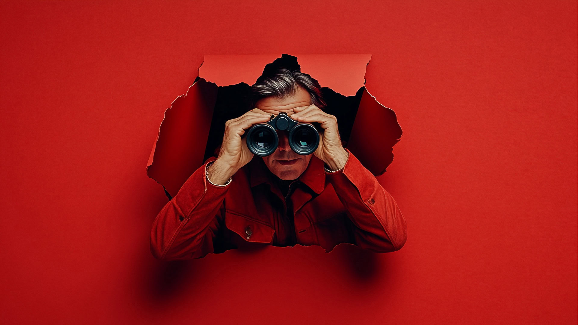 Ein Mann in roter Kleidung schaut durch ein Fernglas und lehnt sich durch ein aufgerissenes Loch in einer roten Wand. Sein Blick wirkt suchend und neugierig. Das Bild symbolisiert die Idee der Nichtkunden in der Blue-Ocean-Strategie – potenzielle Märkte und Kundengruppen, die bisher übersehen wurden und neue Wachstumschancen bieten.