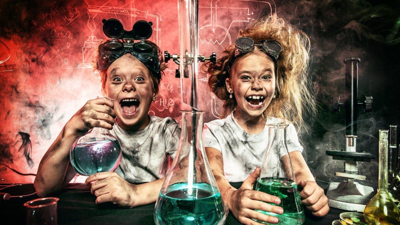 Zwei Mädchen mit rußverschmierten Gesichtern freuen sich über ein fehlgeschlagenes Experiment.