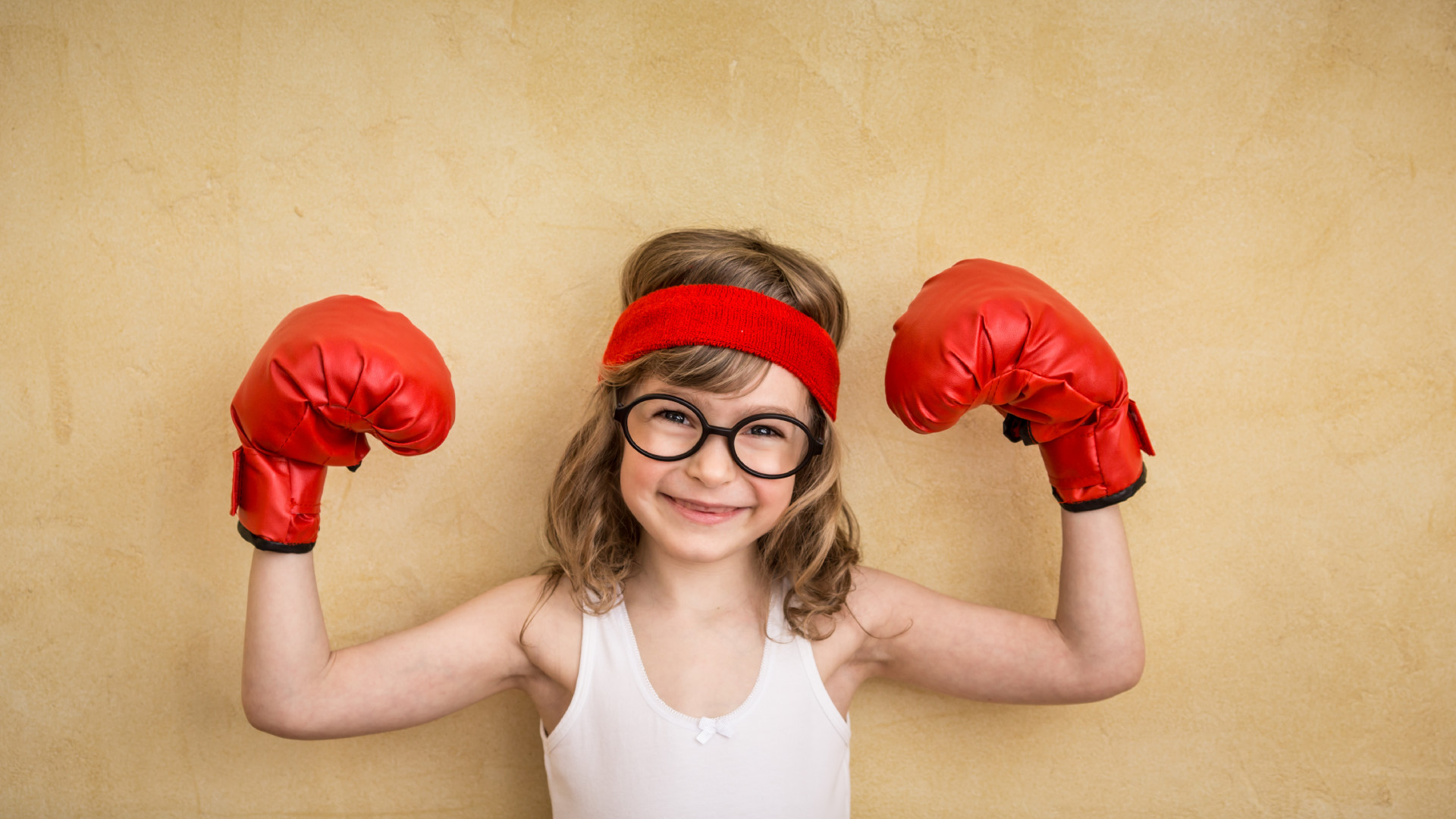 Kleines Mädchen mit Boxhandschuhen, das mit der VRIO-Methode ihr Geschäftsmodell geschützt hat.