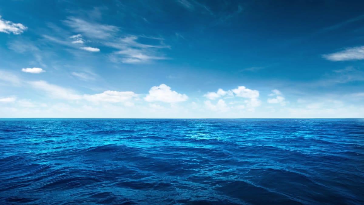 Weitläufige, unberührte Meeresfläche unter einem klaren blauen Himmel mit weißen Wolken – eine symbolische Darstellung der Bl