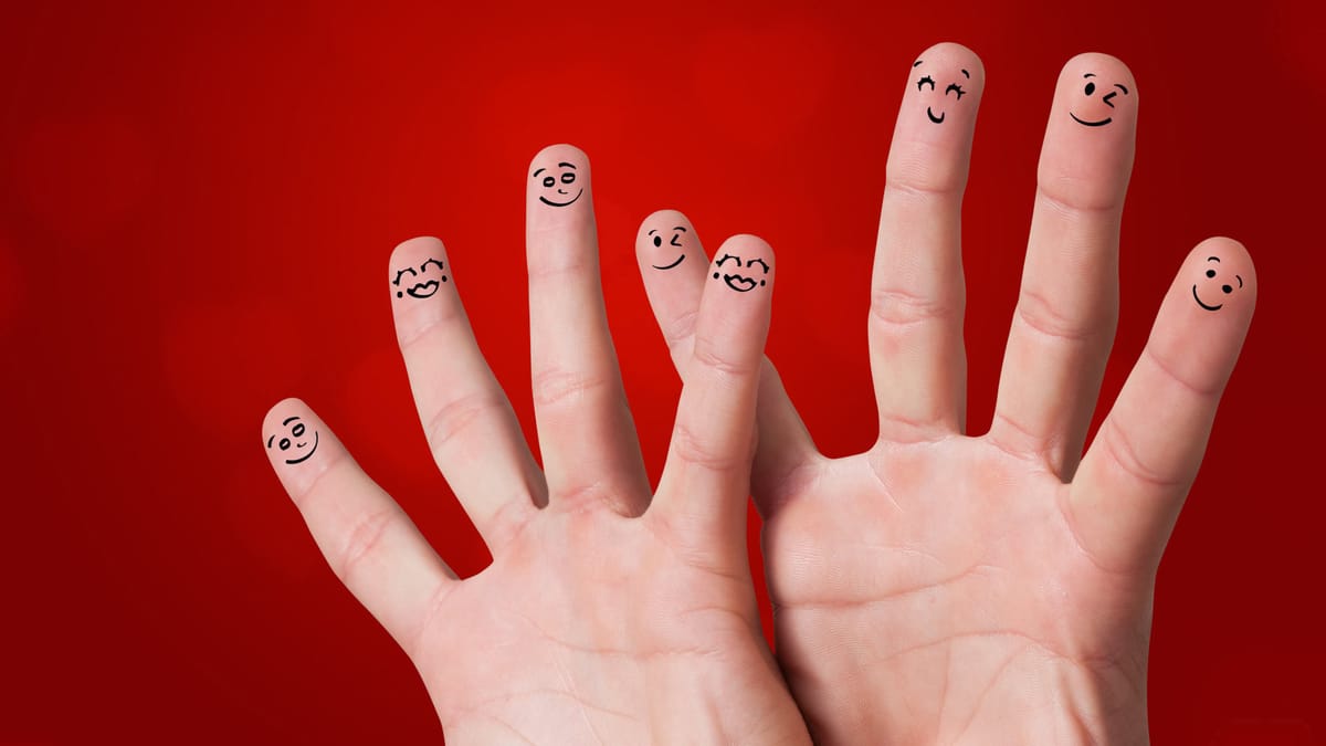 Zwei offene Hände vor einem roten Hintergrund, auf deren Fingerspitzen mit schwarzer Tinte gezeichnete Gesichter zu sehen sin