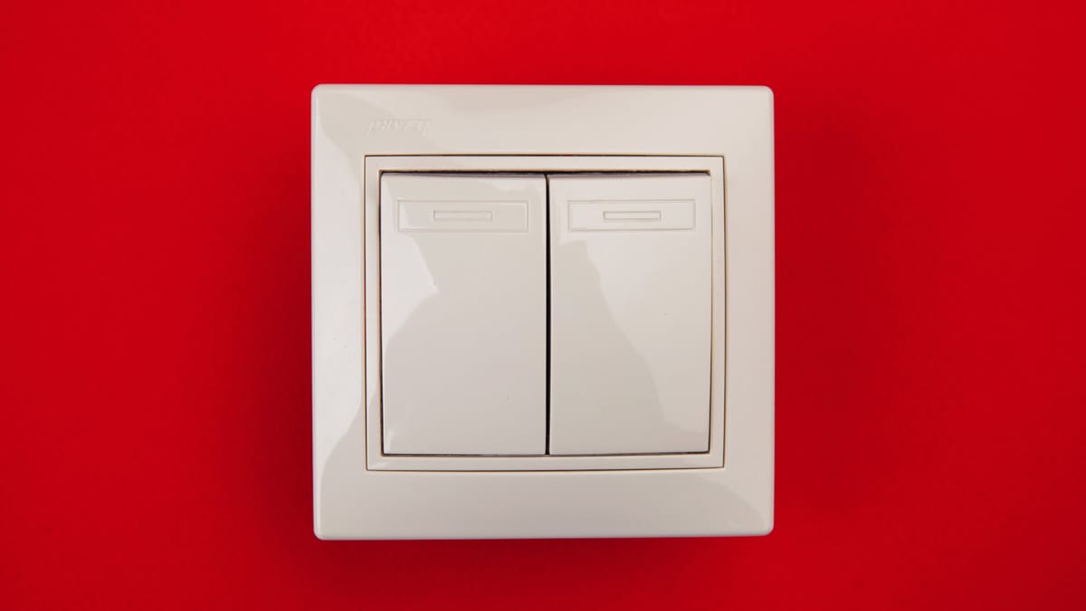 Ein weißer Doppelschalter auf rotem Hintergrund veranschaulicht das Konzept der Switch Interviews.
