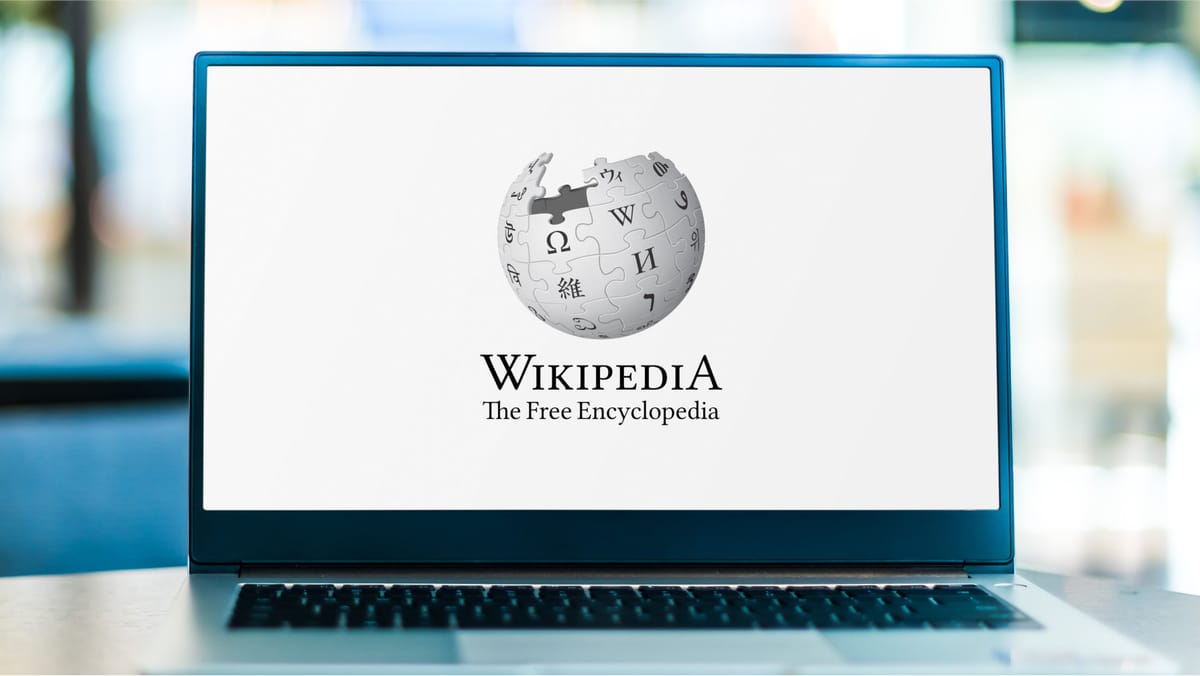 Laptop auf dessen Bildschirm das Wikipedia-Logo zu sehen ist.